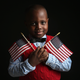 Ifeozuwa Oyaniyi, 5, born in Nigeria, holds flags given to him by the U.S. Citizenship and Immigration Services while waiting to receive his citizenship certificate on Feb. 19, 2013, in New York City. (John Moore/Getty Images)
